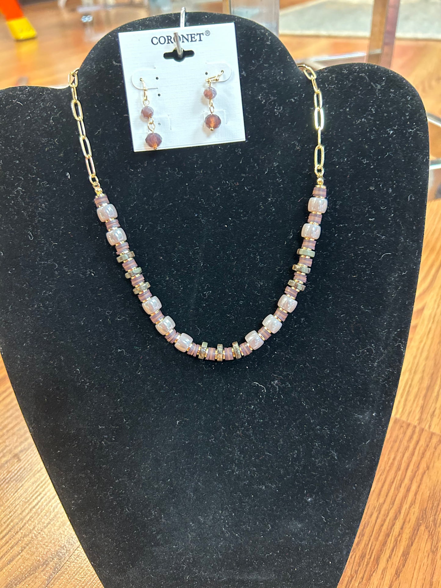 Single layer necklace in a shorter length. Shades of purple on a gold chain. Matching earrings complete the set